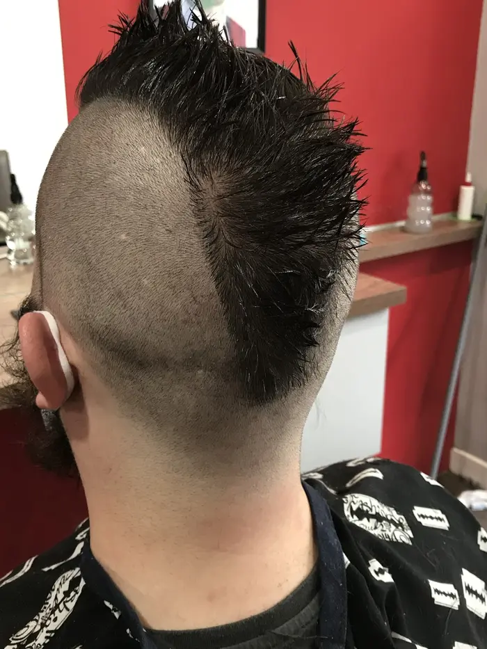 Close skin fade haircut with a sharp mohawk hairline, back view