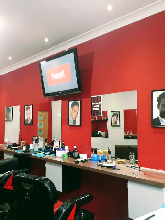 Interior of First Class Barbers Hot Shave, mirrors and barber chairs against red walls