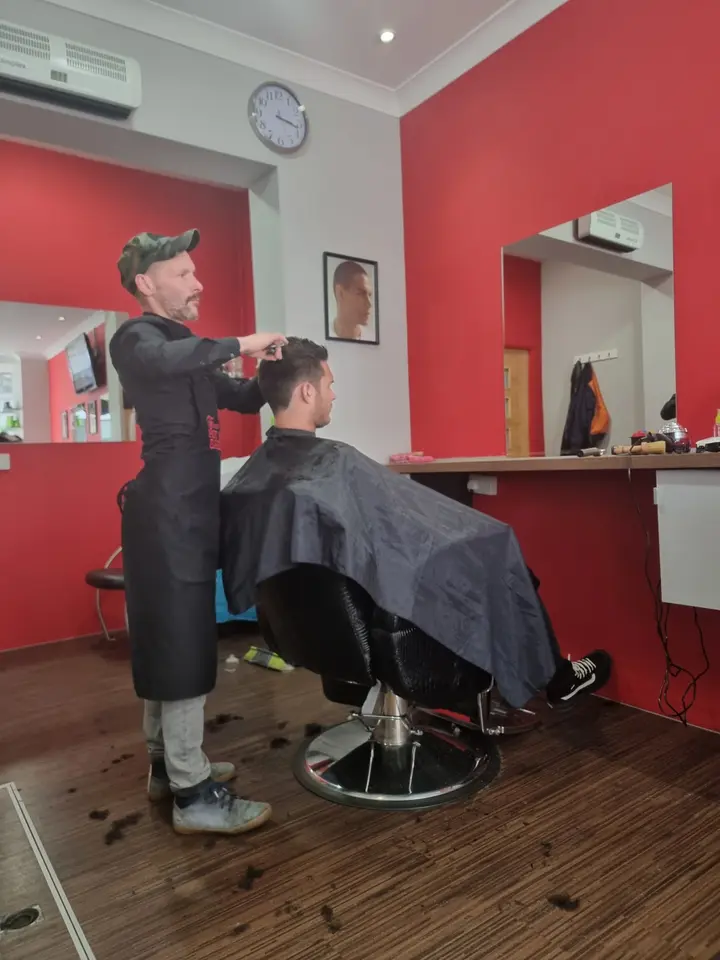 Barber cutting a customer's hair in the shop, First Class Barbers Morningside